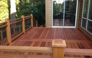 A beautifully designed Fijian Mahogany deck featuring a rich, reddish-brown finish, complemented by a custom wood and metal railing, perfect for luxury outdoor spaces in Ontario.