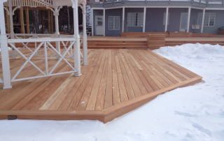 A durable Fijian Mahogany deck standing strong in snowy conditions, highlighting its superior rot resistance and longevity for outdoor spaces.