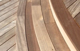 Close-up of curved genuine Fijian mahogany decking, showcasing precision craftsmanship and natural wood tones.