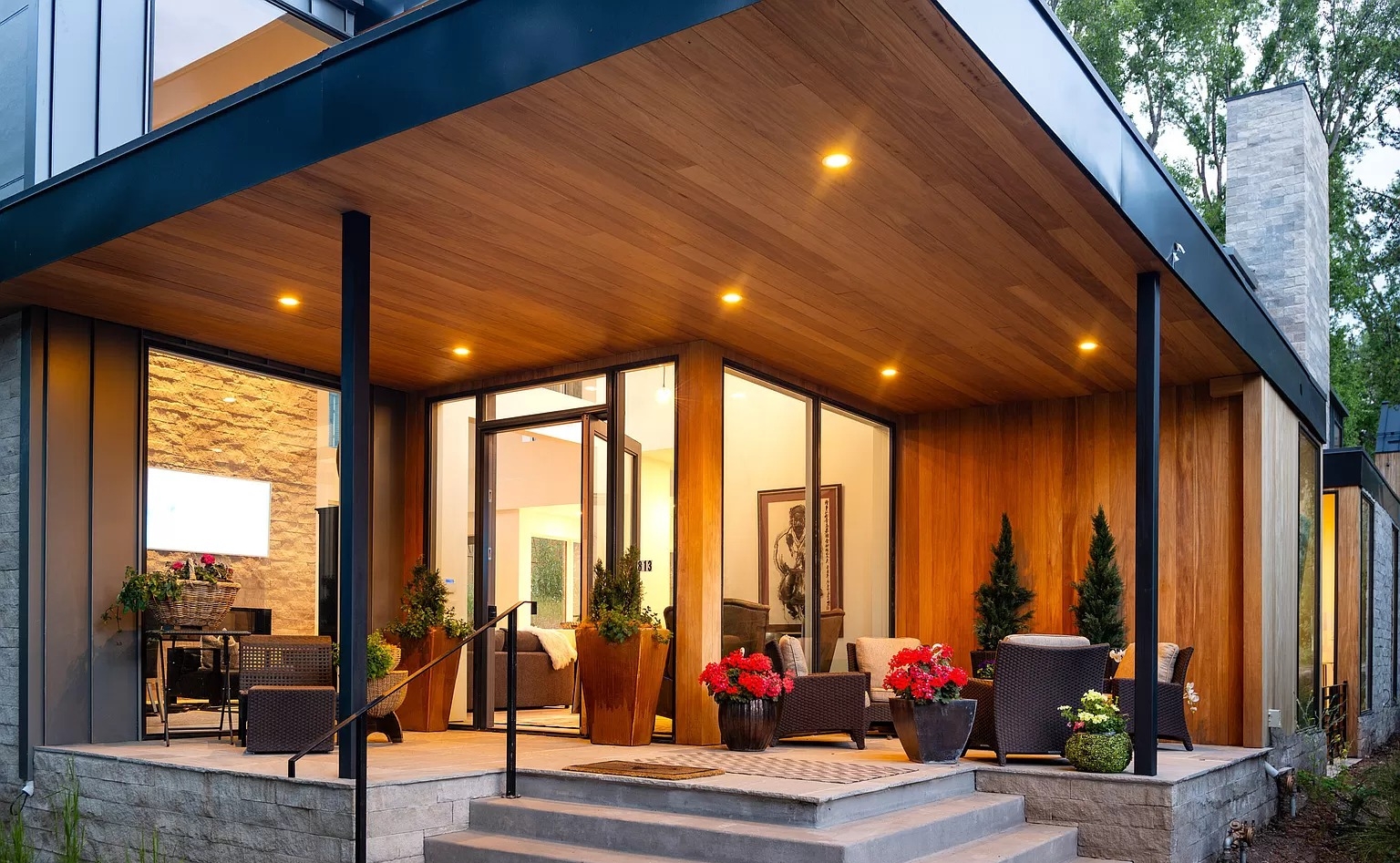 Fijian Mahogany Ceiling and Siding on Modern Patio Modern home featuring Fijian Mahogany ceiling and siding with warm lighting and outdoor seating area.