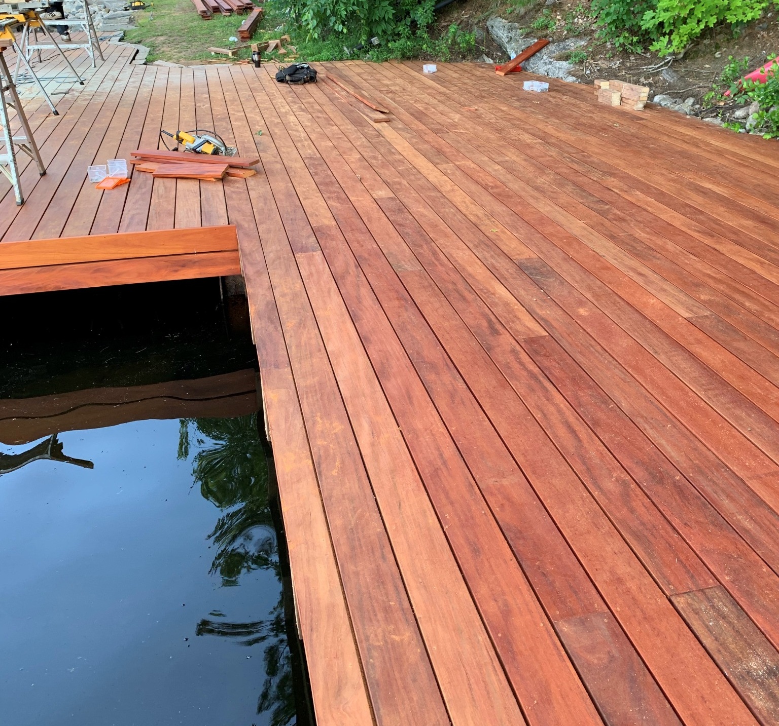 Newly installed genuine Fijian mahogany dock extending over the water, showcasing rich tones and natural wood grain.